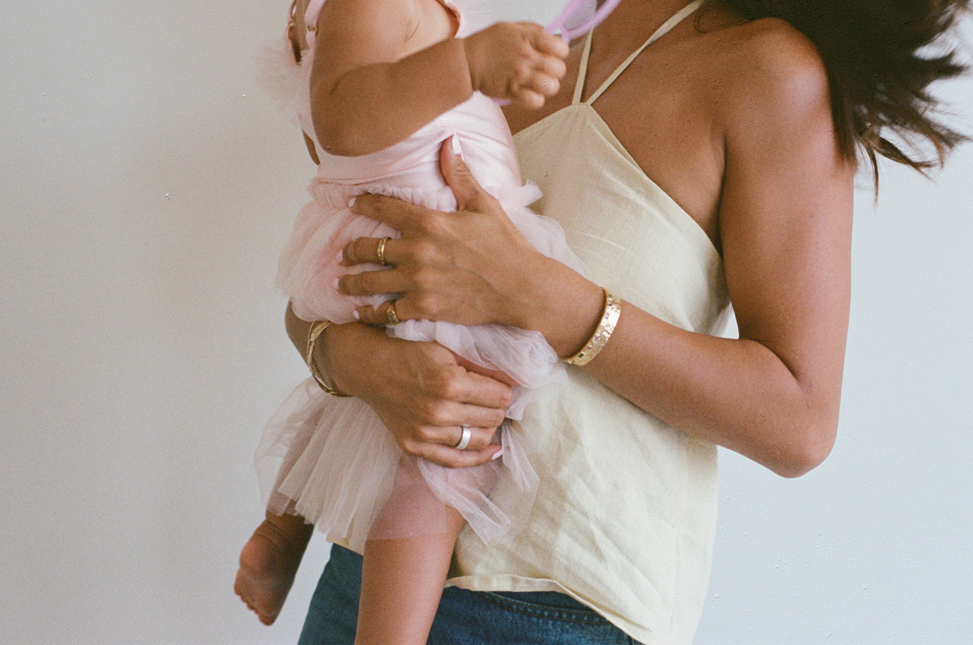 A local nanny holding a baby in a soft pink tutu